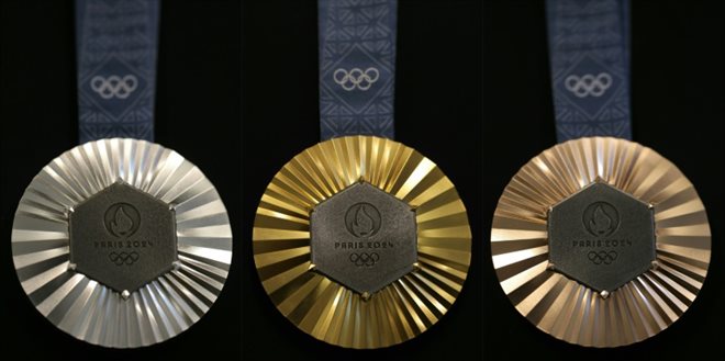 Combinaison de photos prises le 30 janvier 2024 à Paris montrant les médailles (argent, or et bronze, de gauche à droite) des prochains Jeux olympiques de Paris 2024 conçues par la maison française de joaillerie de luxe Chaumet (groupe LVMH) et révélées au public le 8 février 2024.