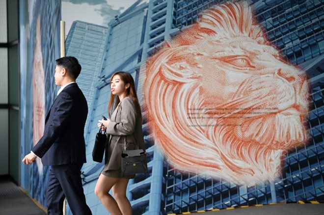 Des passants devant la HSBC à Hong Kong le 21 février 2024