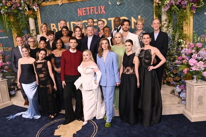Le PDG de Netflix Netflix Ted Sarandos (au centre) pose avec le casting de la saison 3 des Bridgerton  le 13 mai 2024 à New York