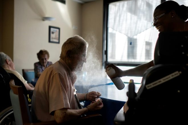 A nurse sprays water on a resident in a retirement home in Lyon on July 2, 2015.