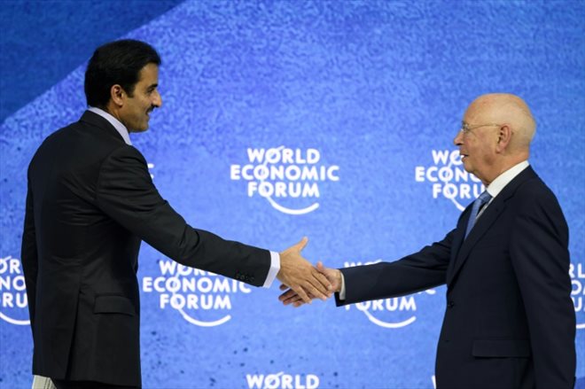 Qatar's Emir Sheikh Tamim bin Hamad al-Thani (left) shakes hands with founder and chairman of the World Economic Forum in Davos, Switzerland, Klaus Schwab, during the organization's annual meeting on May 23 2022