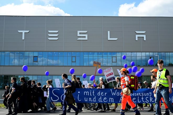 Des manifestants écologistes défilent devant l'usine de Tesla à Grünheide (près de Berlin, en Allemagne) pour protester contre un projet d'agrandissement, le 11 mai 2024