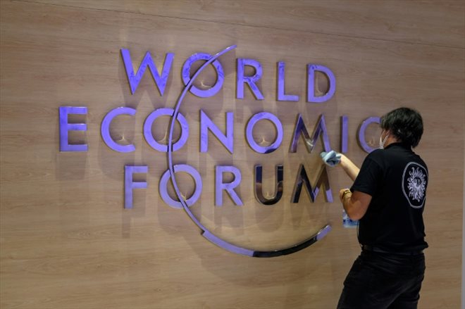 A worker cleans the logo of the World Economic Forum (WEF) inside the congress center in Davos, Switzerland, on May 22, 2022.