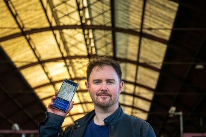 Nicolas Wurtz shows on his phone his application providing real-time movement of French trains, in Strasbourg, May 25, 2023