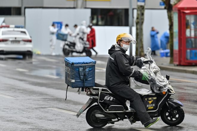 A delivery man on a scooter leaves to deliver an order to residents of a confined area of ​​Shanghai after the appearance of new cases of Covid-19, March 17, 2022 in China.