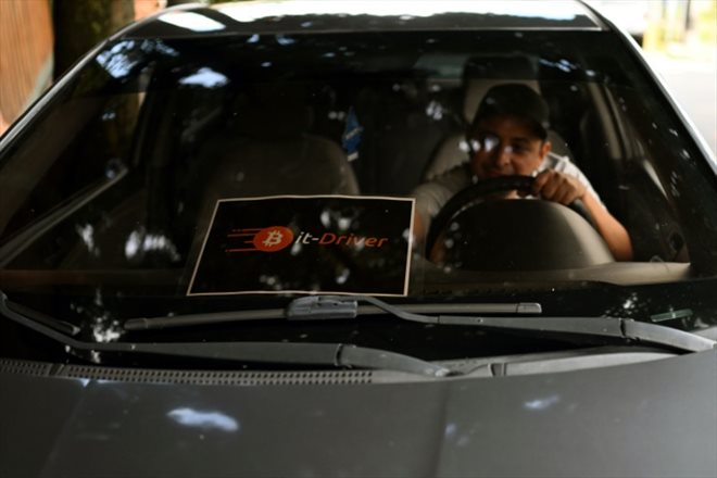 Napoleón Osorio a apposé sur le pare-brise de son taxi un panneau informant les clients qu'il accepte les paiements en bitcoins, à San Salvador le 4 septembre 2024