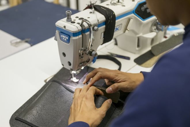 Davy Dao, fondateur de la marque textile Dao, coud un sac en cuir végétal de lin au siège de l'entreprise à Maxeville, le 23 novembre 2023 en Meurthe-et-Moselle